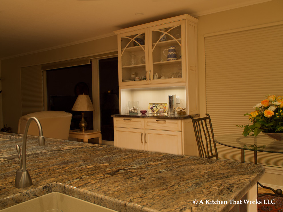 Eat-in kitchen - large transitional u-shaped medium tone wood floor and brown floor eat-in kitchen idea in Seattle with an undermount sink, recessed-panel cabinets, white cabinets, granite countertops, stone slab backsplash, stainless steel appliances, an island, brown backsplash and brown countertops
