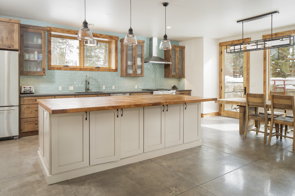 Mid-sized mountain style single-wall eat-in kitchen photo in Denver with an undermount sink, shaker cabinets, distressed cabinets, quartz countertops, blue backsplash, glass tile backsplash, stainless steel appliances, an island and gray countertops