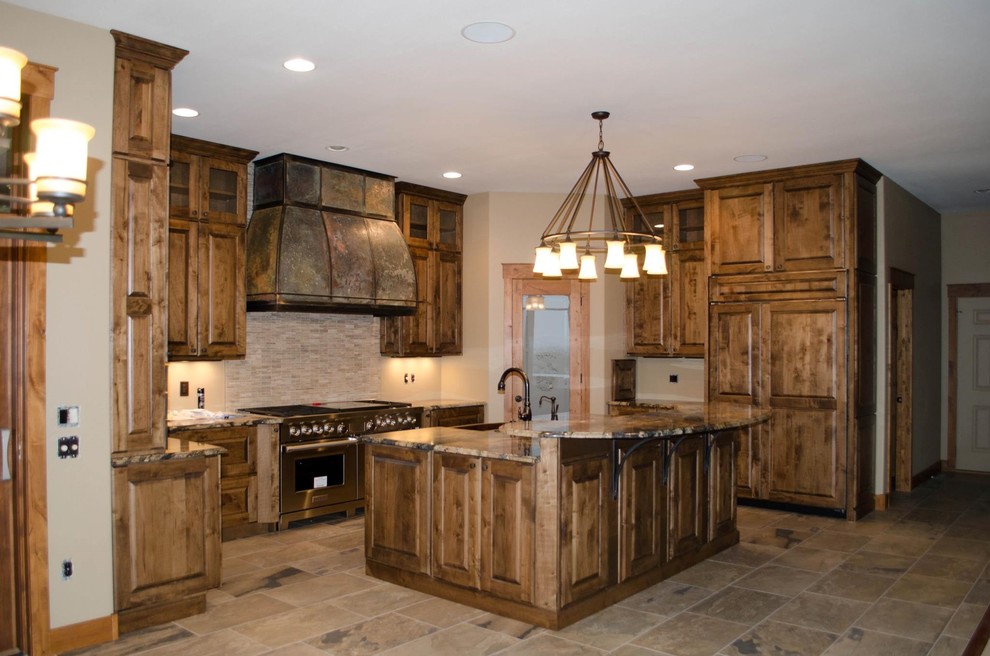 Design ideas for a country kitchen in Other with raised-panel cabinets, distressed cabinets, granite benchtops, beige splashback, stainless steel appliances, porcelain floors and with island.