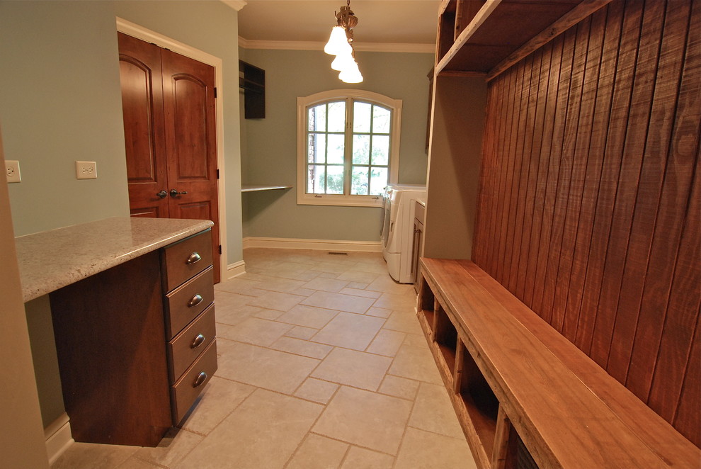 Photo of a large transitional galley utility room in Chicago with granite benchtops, flat-panel cabinets, blue walls, porcelain floors, a side-by-side washer and dryer and dark wood cabinets.