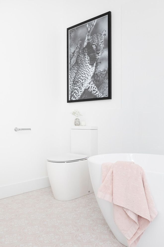 Inspiration for a large contemporary master bathroom in Brisbane with shaker cabinets, white cabinets, a freestanding tub, an open shower, a one-piece toilet, white tile, porcelain tile, white walls, ceramic floors, an undermount sink, engineered quartz benchtops, pink floor, a sliding shower screen and white benchtops.