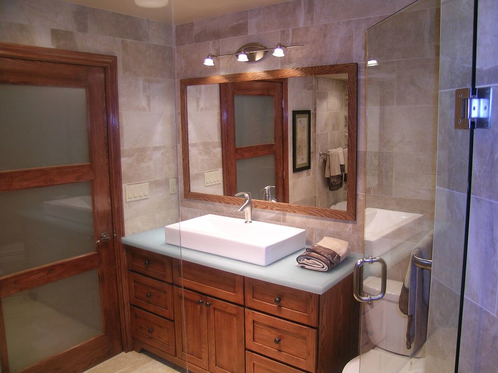 Example of a mid-sized transitional master beige tile and porcelain tile corner shower design with recessed-panel cabinets, dark wood cabinets, glass countertops, a hinged shower door and blue countertops