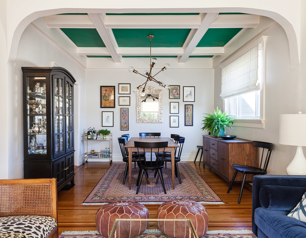Design ideas for an eclectic dining room in San Francisco with white walls, medium hardwood floors and brown floor.