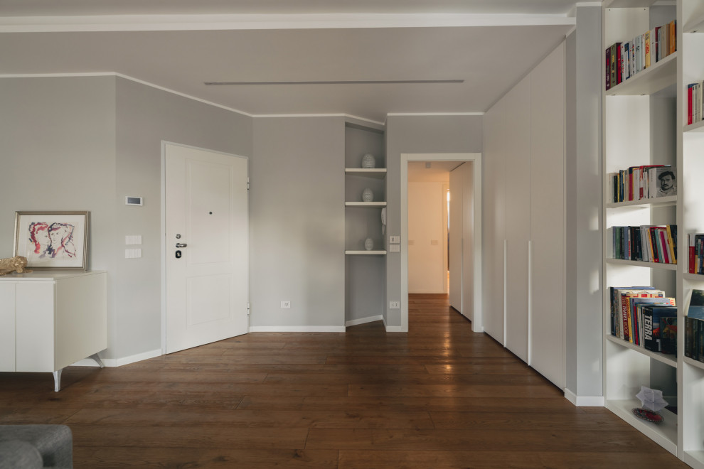 Стильный дизайн: фойе среднего размера в современном стиле с серыми стенами, деревянным полом, одностворчатой входной дверью, белой входной дверью, коричневым полом и многоуровневым потолком - последний тренд