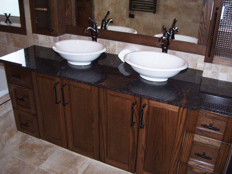 Example of a mid-sized transitional master beige tile and ceramic tile ceramic tile and beige floor drop-in bathtub design with shaker cabinets, dark wood cabinets, beige walls, a vessel sink and granite countertops