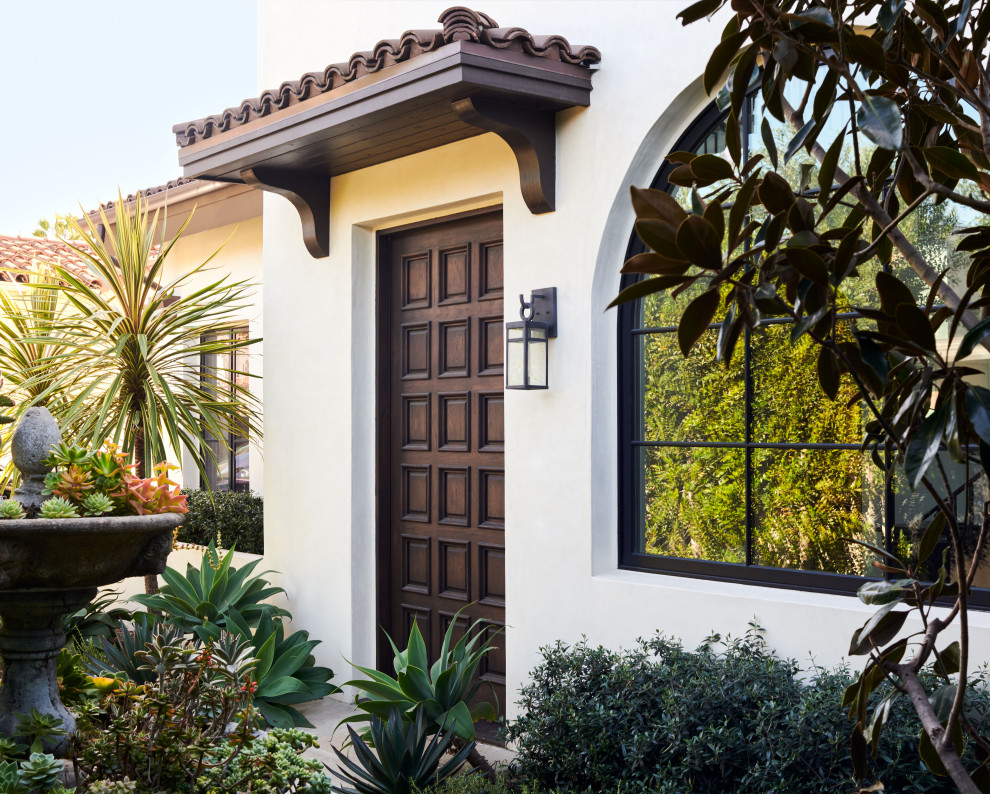 Design ideas for a large mediterranean front door in Los Angeles with white walls, concrete floors, a single front door, a brown front door and grey floor.