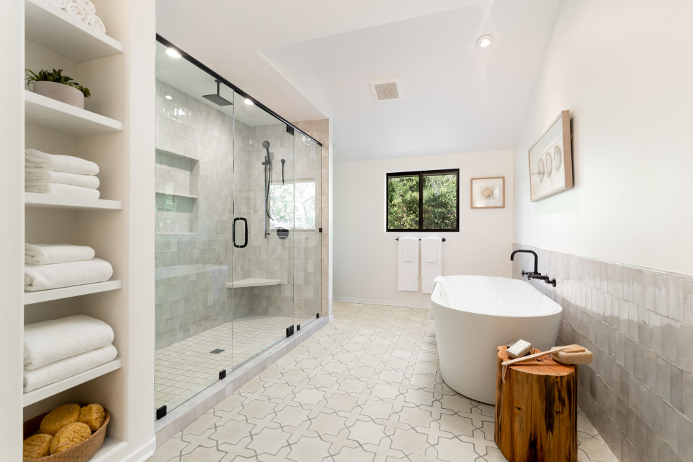 Пример оригинального дизайна: большая главная ванная комната в современном стиле с светлыми деревянными фасадами, отдельно стоящей ванной, двойным душем, белой плиткой, керамической плиткой, полом из цементной плитки и белым полом