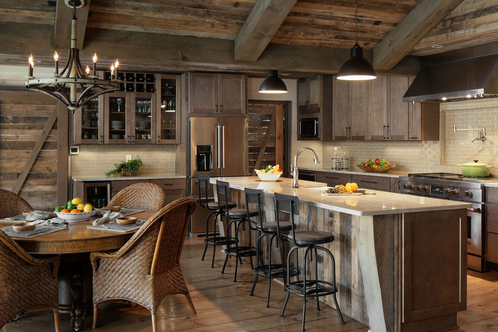 Photo of a country l-shaped eat-in kitchen in Other with a farmhouse sink, shaker cabinets, dark wood cabinets, beige splashback, stainless steel appliances, medium hardwood floors, with island, brown floor and beige benchtop.