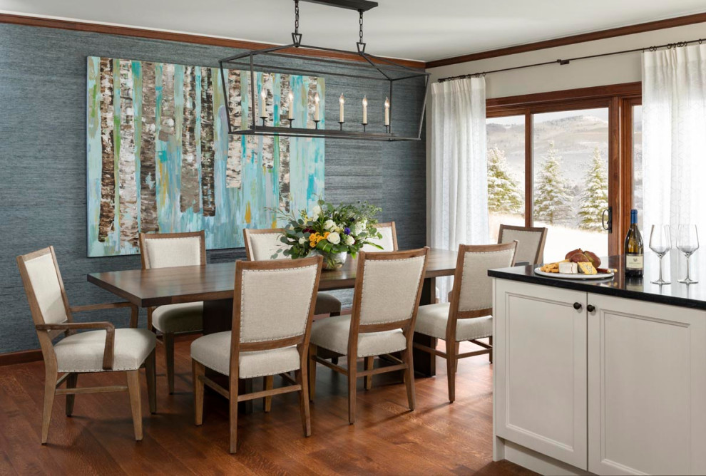Inspiration for a mid-sized transitional dining room in Denver with blue walls, medium hardwood floors, brown floor and wallpaper.