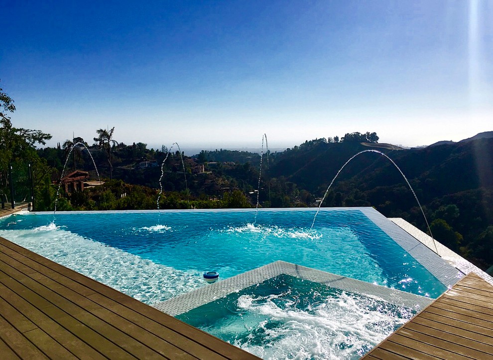 Mid-sized minimalist backyard tile and custom-shaped infinity pool photo