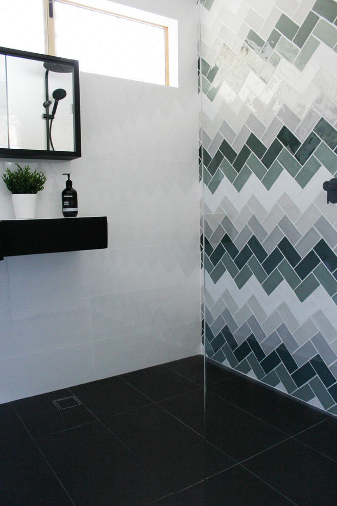 This is an example of a small modern 3/4 bathroom in Perth with open cabinets, black cabinets, an open shower, multi-coloured tile, subway tile, multi-coloured walls, porcelain floors, a pedestal sink, solid surface benchtops, black floor, an open shower and white benchtops.