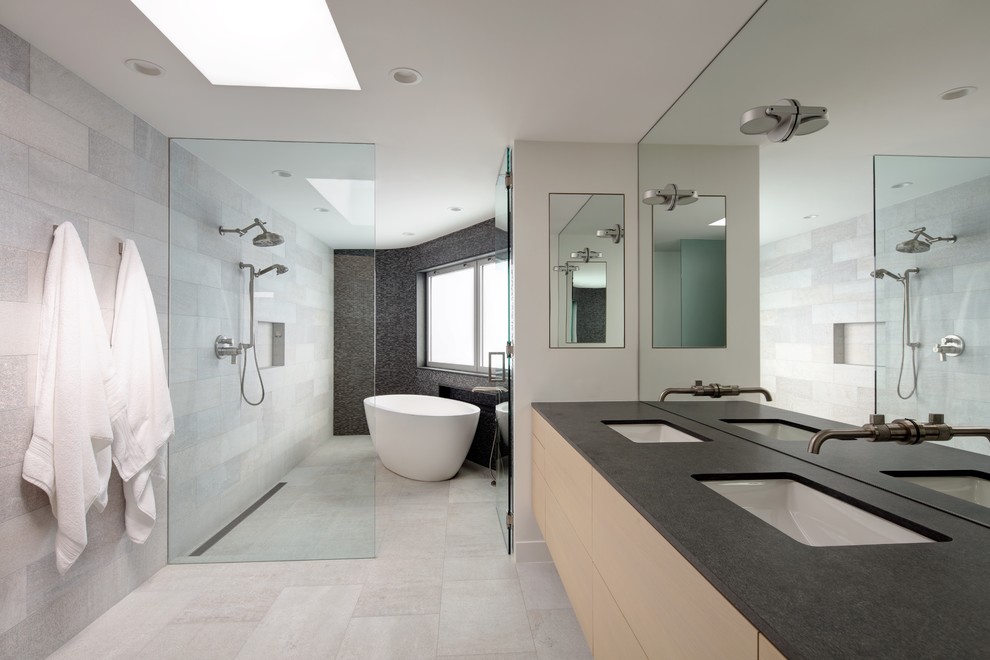 Inspiration for a large scandinavian master wet room bathroom in Los Angeles with flat-panel cabinets, light wood cabinets, a freestanding tub, ceramic floors, an integrated sink, granite benchtops, beige floor, a hinged shower door and white benchtops.