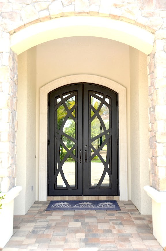 This is an example of a large mediterranean front door in Tampa with a double front door and a metal front door.