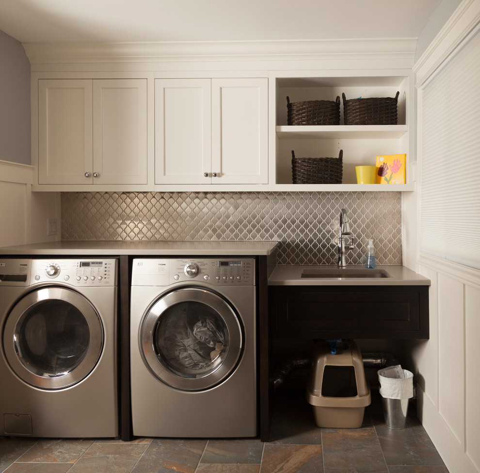 This is an example of a transitional single-wall laundry room in Toronto with shaker cabinets, white cabinets, quartz benchtops and a side-by-side washer and dryer.