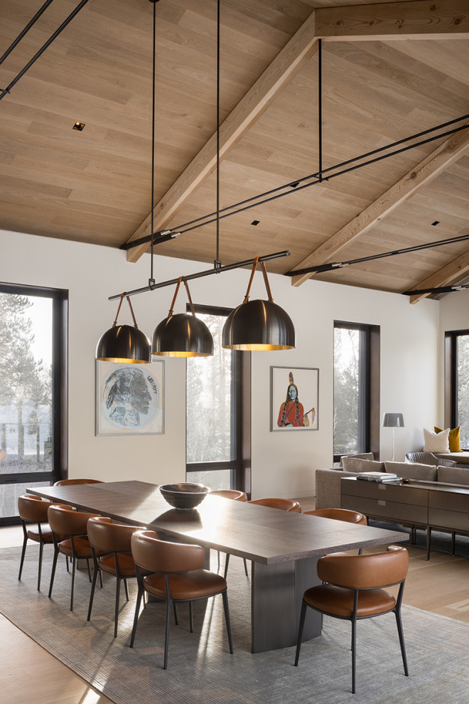 Cette photo montre une salle à manger ouverte sur la cuisine montagne avec un mur blanc, parquet clair et un plafond en bois.