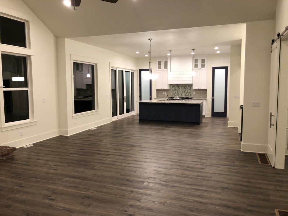 Inspiration for a large transitional u-shaped kitchen pantry remodel with an undermount sink, recessed-panel cabinets, white cabinets, gray backsplash, ceramic backsplash, stainless steel appliances, an island and multicolored countertops