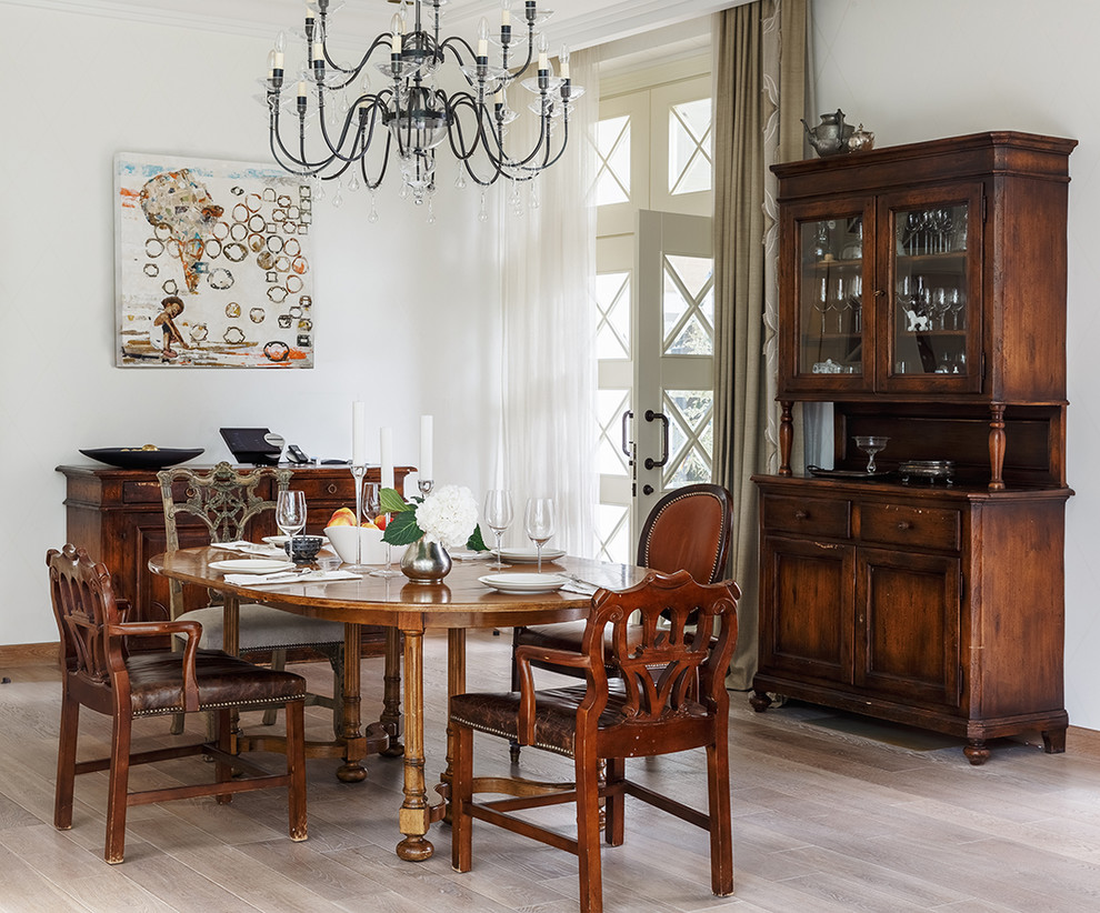 This is an example of a transitional dining room in Moscow with white walls, light hardwood floors and beige floor.