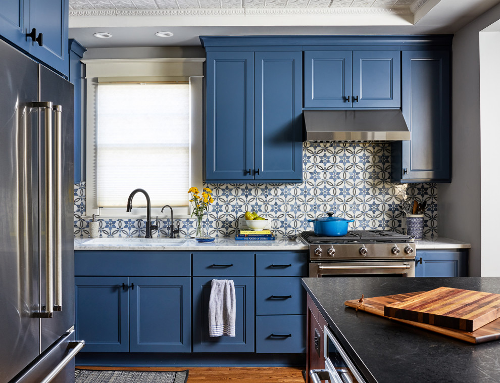 Foto di una cucina classica di medie dimensioni con ante blu, paraspruzzi blu, elettrodomestici in acciaio inossidabile e pavimento in legno massello medio