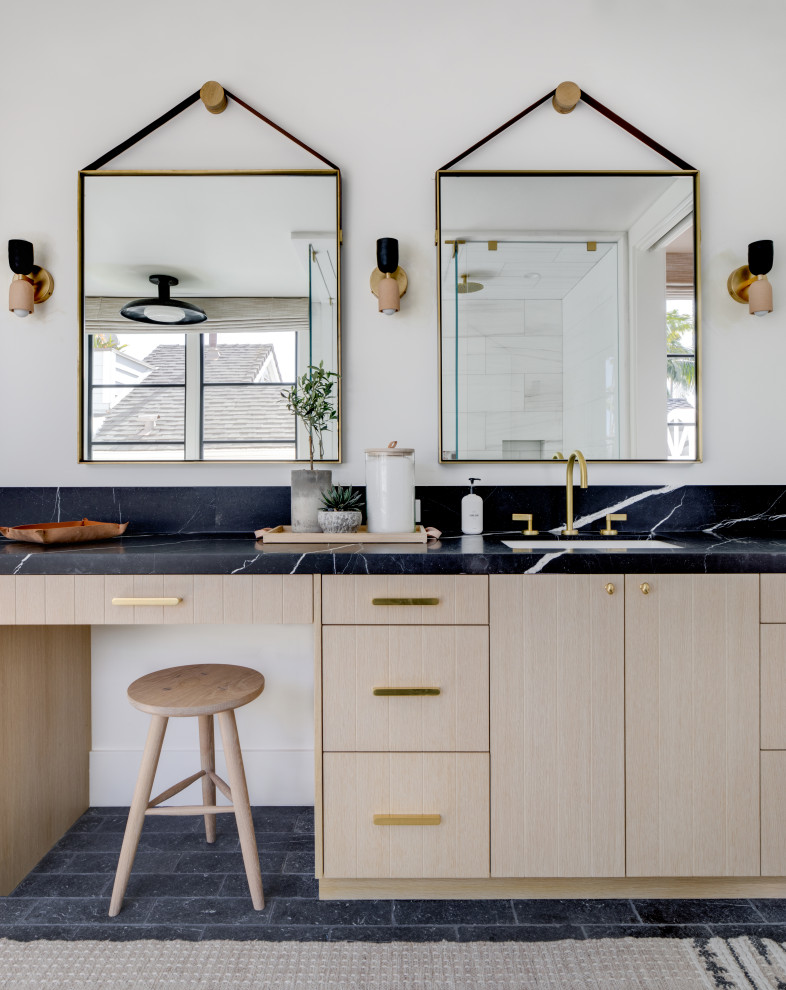 Bathroom - transitional black floor and single-sink bathroom idea with flat-panel cabinets, light wood cabinets, white walls, an undermount sink, black countertops and a built-in vanity