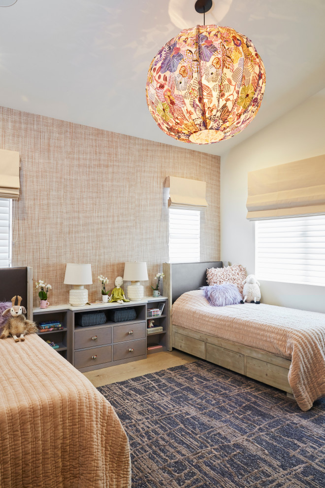 This is an example of a transitional kids' bedroom for girls in San Francisco with multi-coloured walls, light hardwood floors, beige floor, vaulted and wallpaper.