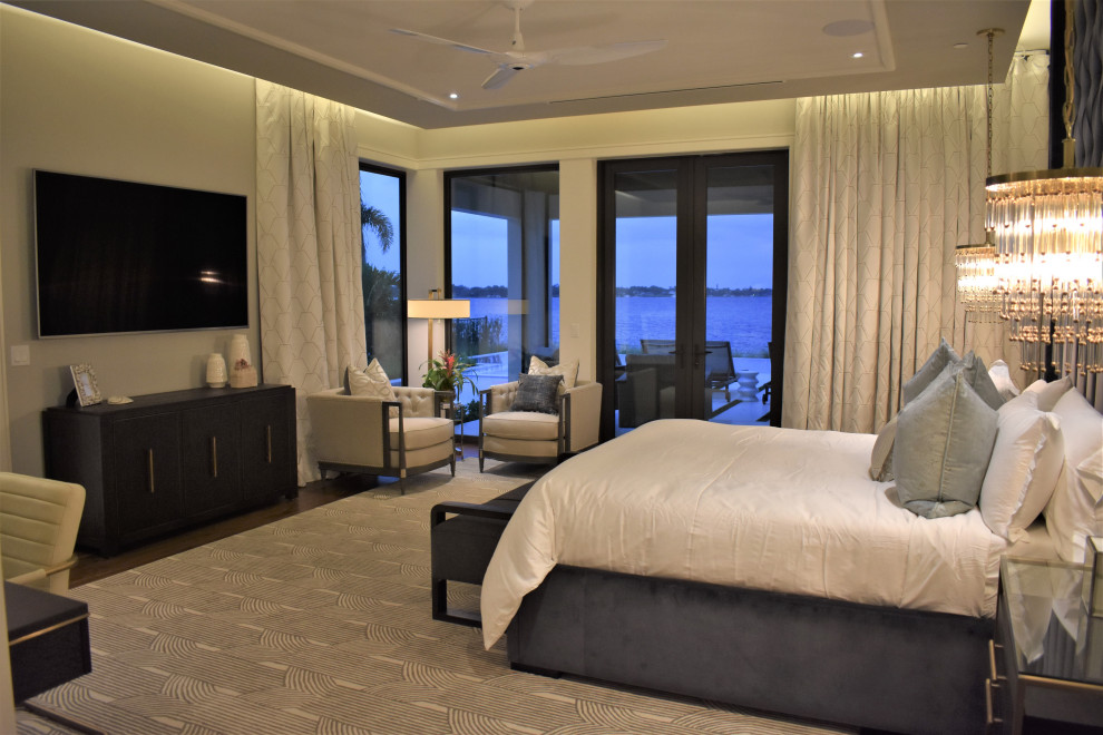 Modelo de dormitorio principal contemporáneo grande con paredes grises, suelo de madera en tonos medios, suelo gris y bandeja