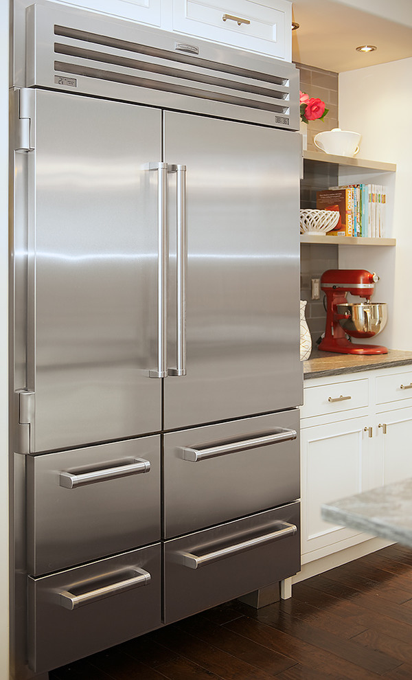 Inspiration for a mid-sized transitional l-shaped dark wood floor and brown floor open concept kitchen remodel in San Francisco with an undermount sink, recessed-panel cabinets, white cabinets, quartz countertops, beige backsplash, subway tile backsplash, stainless steel appliances and an island