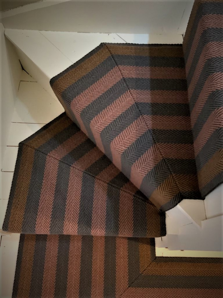 На фото: большая лестница на больцах в современном стиле с ступенями с ковровым покрытием, ковровыми подступенками и деревянными перилами с