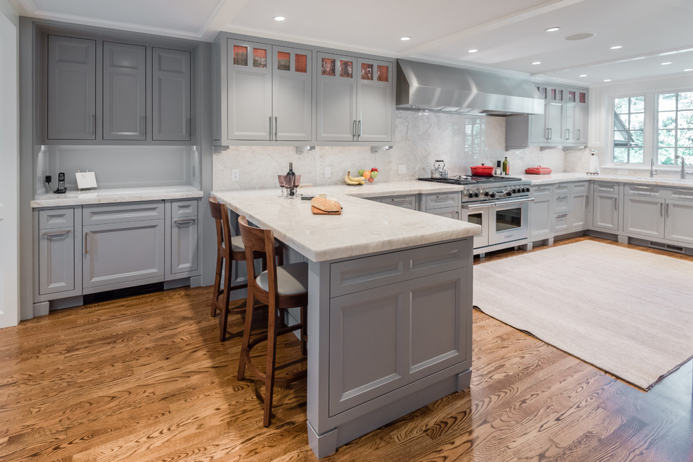 Enclosed kitchen - mid-sized transitional u-shaped medium tone wood floor and brown floor enclosed kitchen idea in Boston with an undermount sink, shaker cabinets, gray cabinets, quartzite countertops, white backsplash, stone slab backsplash, stainless steel appliances and a peninsula