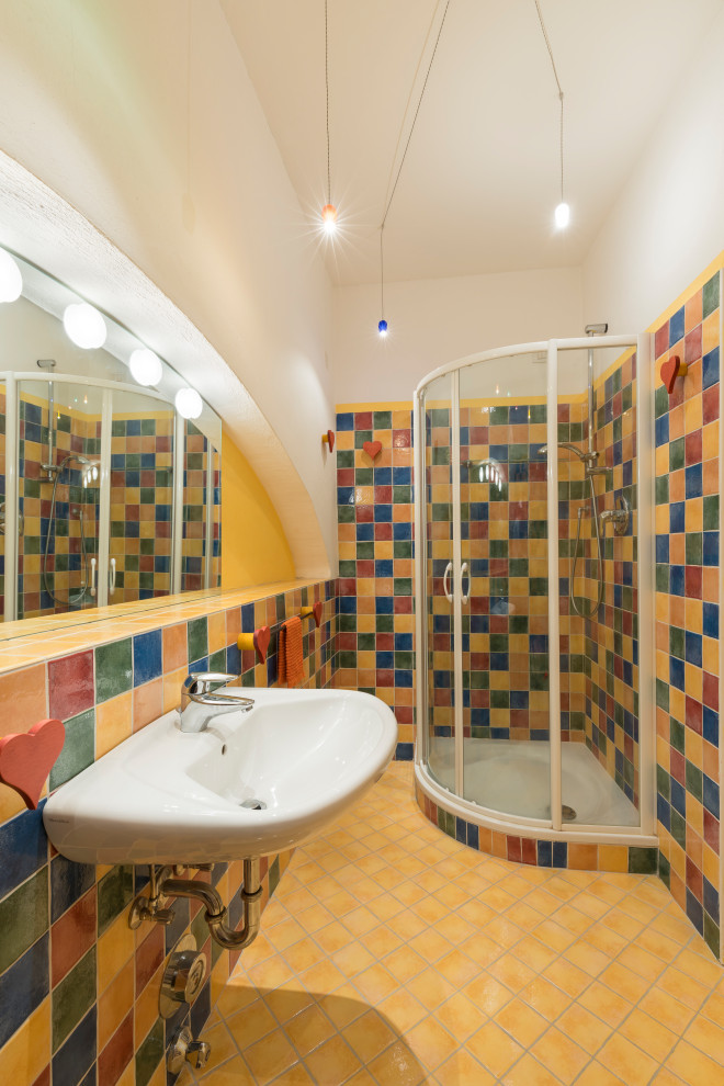 Пример оригинального дизайна: ванная комната среднего размера в стиле рустика с инсталляцией, разноцветной плиткой, керамической плиткой, желтыми стенами, полом из керамической плитки, душевой кабиной, подвесной раковиной, желтым полом, душем с раздвижными дверями и тумбой под одну раковину