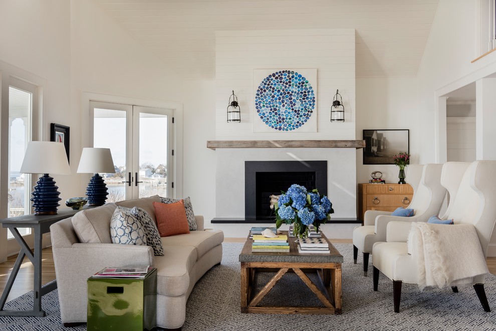 Large beach style open concept living room in New York with white walls, medium hardwood floors, a standard fireplace, a stone fireplace surround, no tv and blue floor.