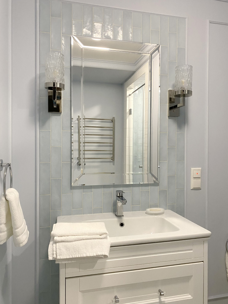 Réalisation d'une salle de bain de taille moyenne avec un placard avec porte à panneau encastré, des portes de placard blanches, WC suspendus, un carrelage bleu, des carreaux de céramique, un mur bleu, un sol en marbre, un lavabo suspendu, un sol beige, une cabine de douche à porte battante, meuble simple vasque et meuble-lavabo suspendu.