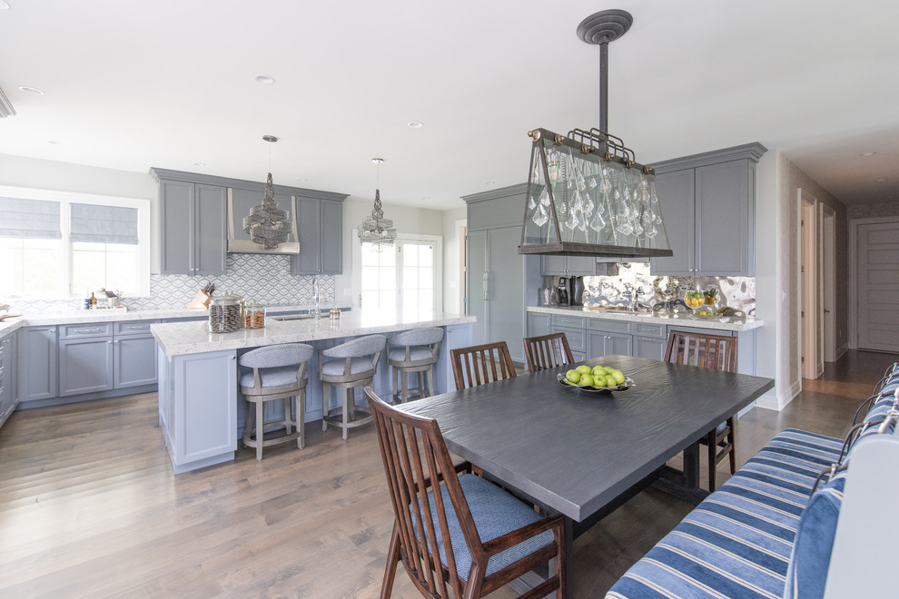 Inspiration for a large transitional medium tone wood floor eat-in kitchen remodel with a single-bowl sink, shaker cabinets, gray cabinets, quartz countertops, multicolored backsplash, mirror backsplash, paneled appliances and an island