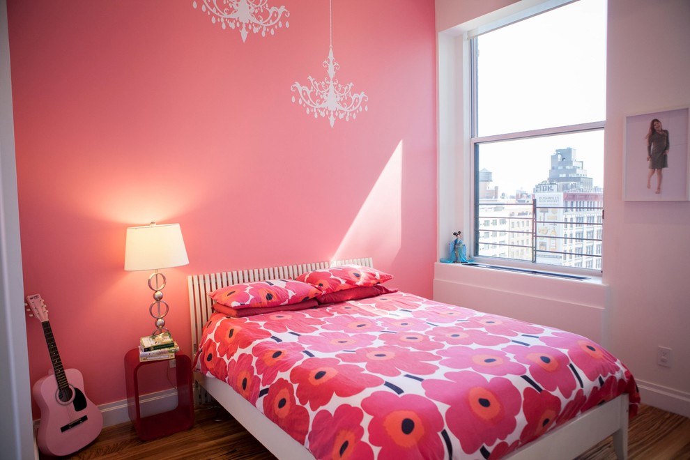 Mid-sized modern guest bedroom in New York with pink walls, medium hardwood floors, no fireplace and brown floor.