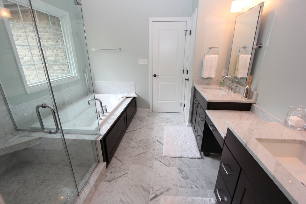 Mid-sized transitional master white tile marble floor drop-in bathtub photo with an undermount sink, flat-panel cabinets, marble countertops, a two-piece toilet, black cabinets and gray walls