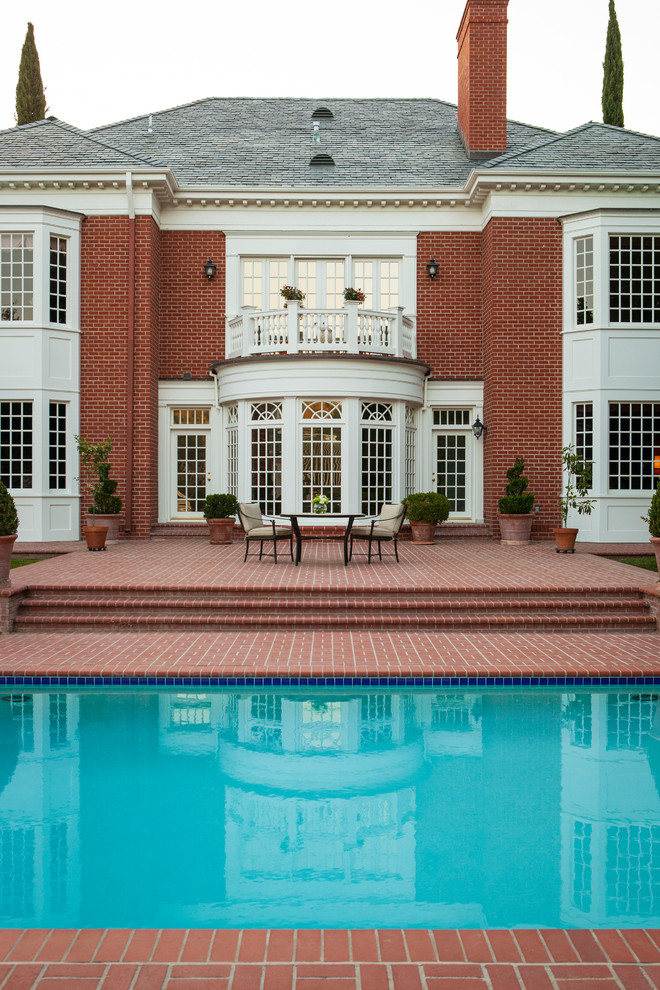 Huge transitional backyard brick and rectangular pool photo in San Diego