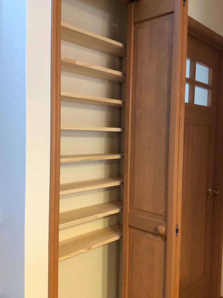 Aménagement d'une armoire encastrée moderne en bois brun de taille moyenne et neutre avec un placard à porte plane, parquet peint, un sol marron et un plafond en papier peint.