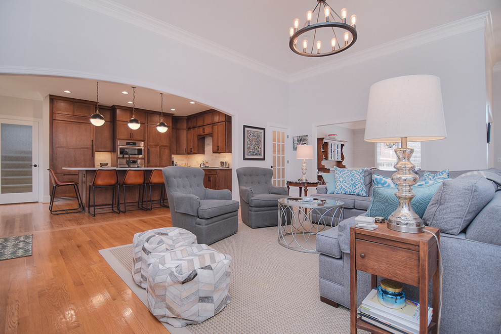 Example of a huge transitional light wood floor open concept kitchen design in Charlotte with a farmhouse sink, shaker cabinets, medium tone wood cabinets, quartzite countertops, an island and white countertops