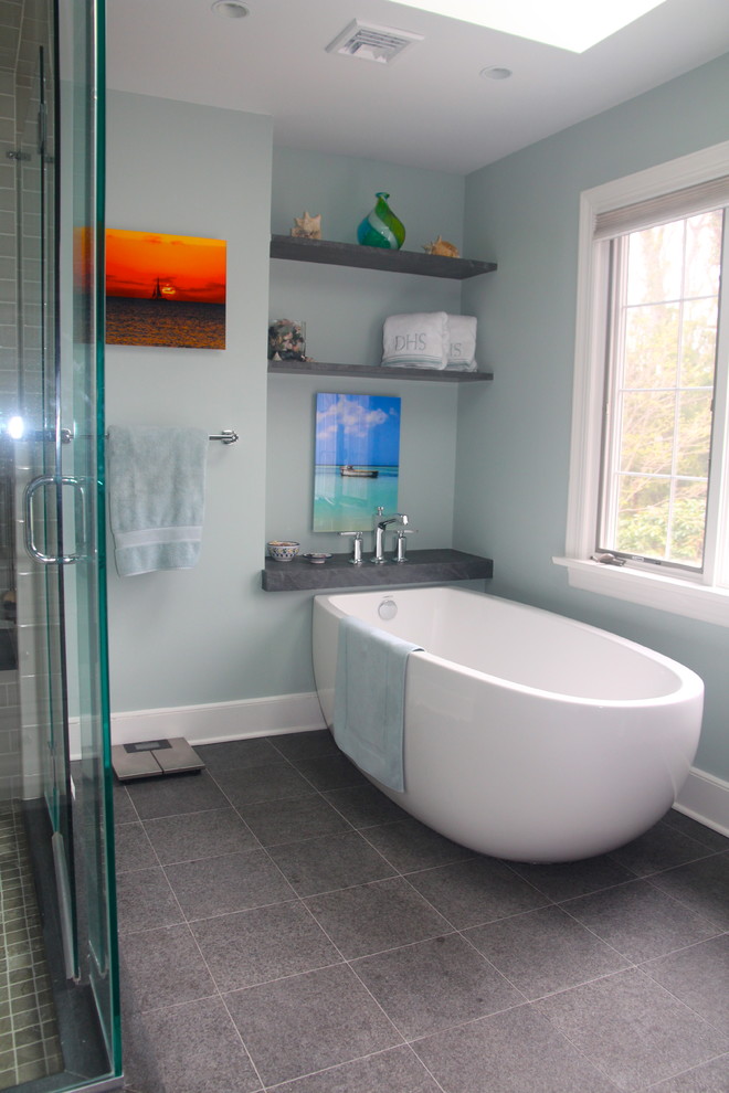 Large beach style master bathroom in New York with a freestanding tub, a corner shower, gray tile and grey walls.