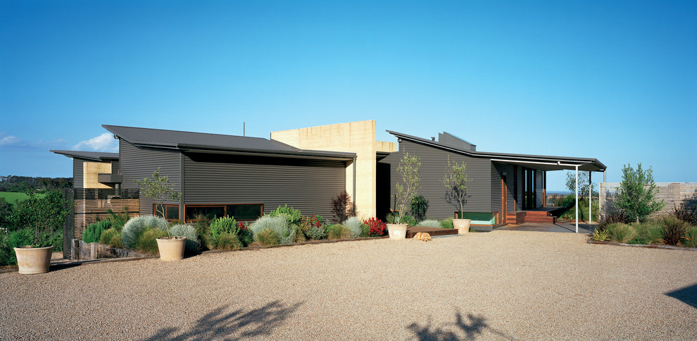 This is an example of a large contemporary split-level grey exterior in Melbourne with metal siding.