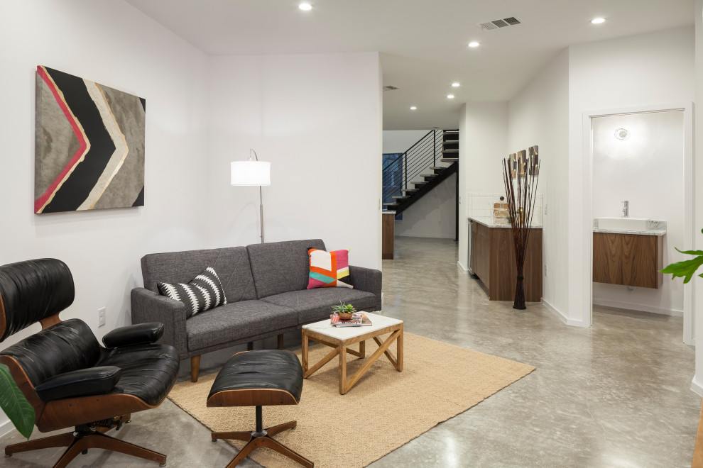 Idee per un soggiorno minimalista aperto con pareti bianche, pavimento in cemento e pavimento grigio
