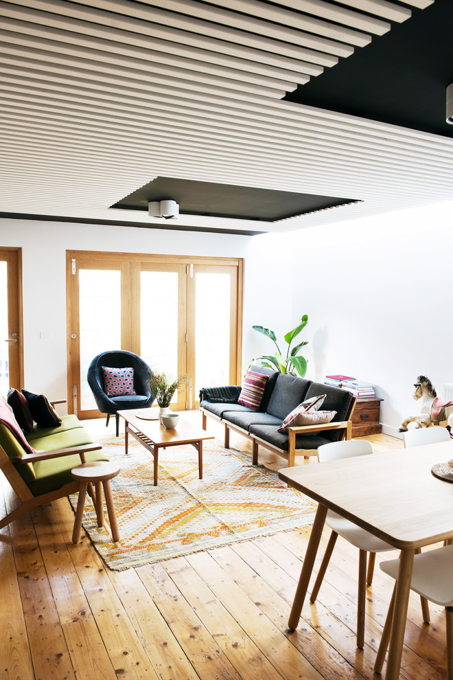 This is an example of a mid-sized scandinavian open concept family room in Melbourne with white walls and light hardwood floors.