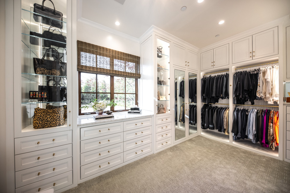 Large transitional gender-neutral walk-in wardrobe with beaded inset cabinets, white cabinets, carpet and grey floor.