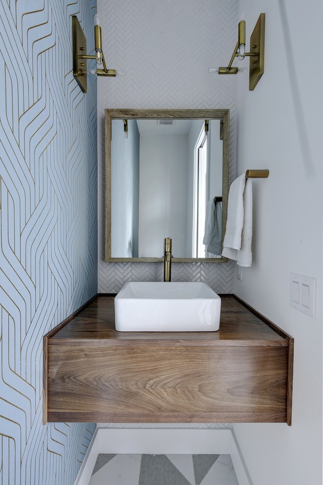 Inspiration for a scandinavian powder room in Austin with flat-panel cabinets, dark wood cabinets, multi-coloured walls, a vessel sink, wood benchtops, multi-coloured floor, brown benchtops, white tile and cement tiles.