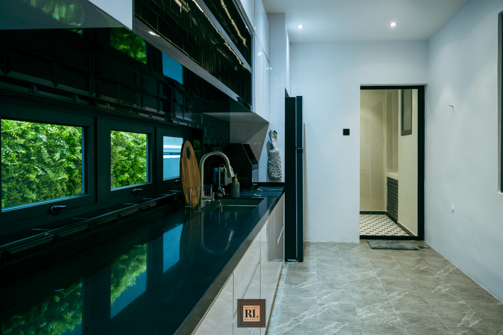 Inspiration for a mid-sized modern single-wall separate kitchen in Other with a drop-in sink, flat-panel cabinets, white cabinets, quartz benchtops, black splashback, subway tile splashback, black appliances, porcelain floors, no island, grey floor, black benchtop and coffered.