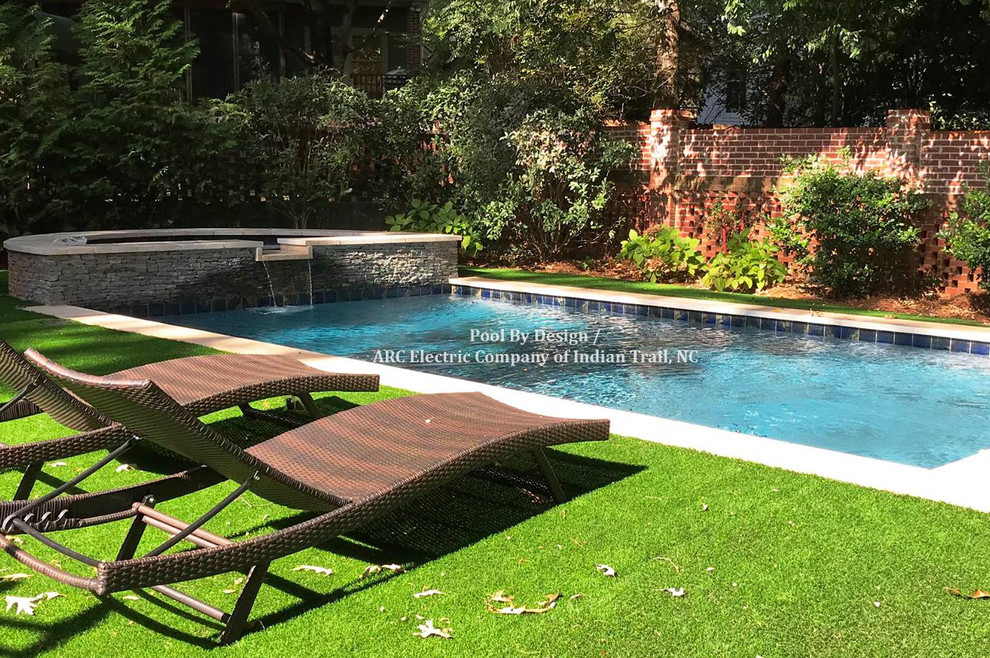 Inspiration for a mid-sized backyard rectangular lap hot tub remodel with decking