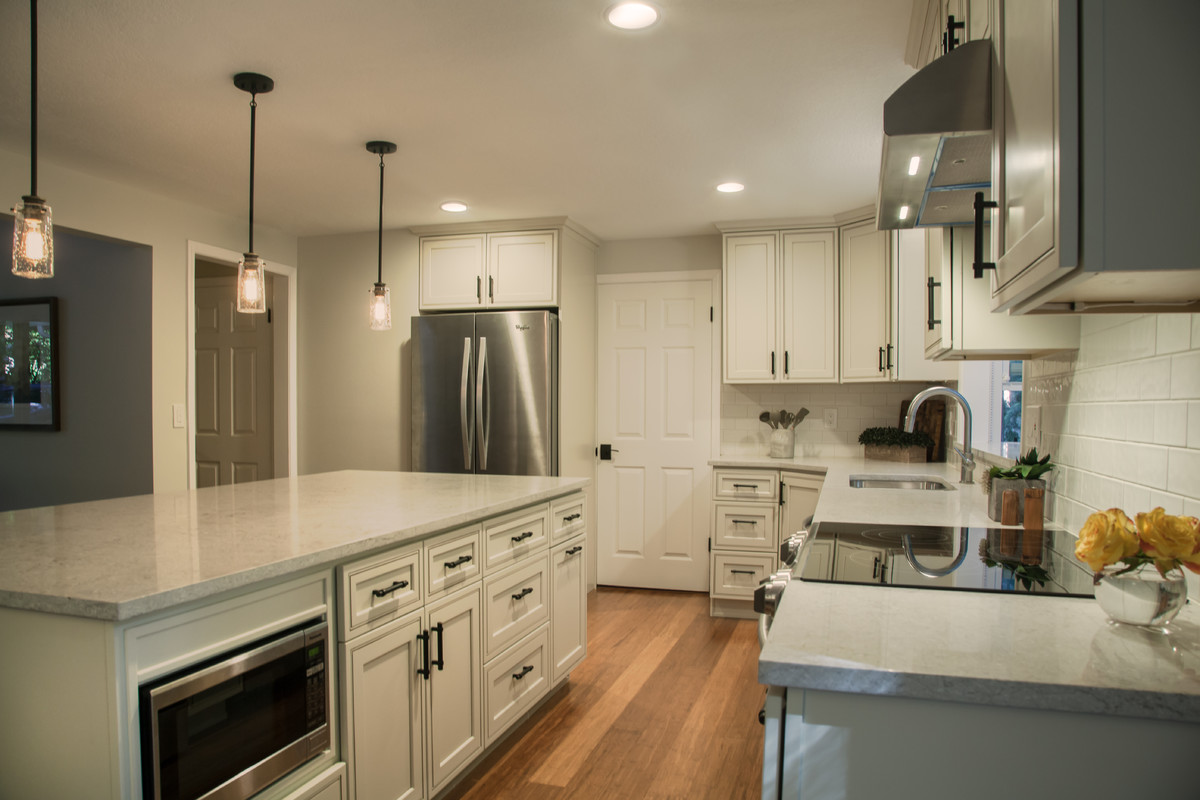 Inspiration for a mid-sized transitional l-shaped bamboo floor and brown floor eat-in kitchen remodel in Seattle with a double-bowl sink, recessed-panel cabinets, quartz countertops, white backsplash, ceramic backsplash, stainless steel appliances and an island