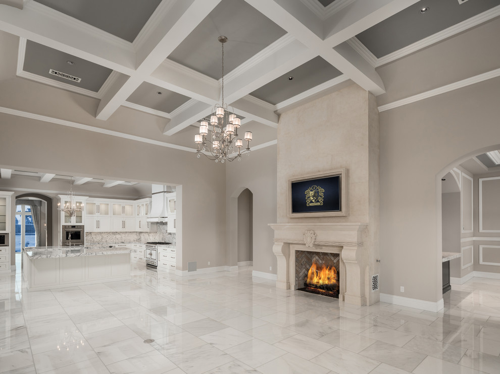 Inspiration for an expansive mediterranean open concept family room in Phoenix with beige walls, marble floors, a standard fireplace, a stone fireplace surround, a wall-mounted tv and multi-coloured floor.