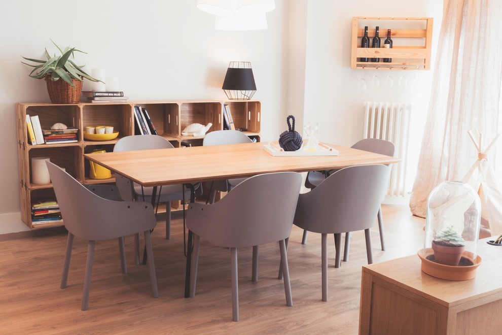 Modelo de comedor nórdico de tamaño medio abierto sin chimenea con paredes blancas, suelo de madera en tonos medios y suelo beige
