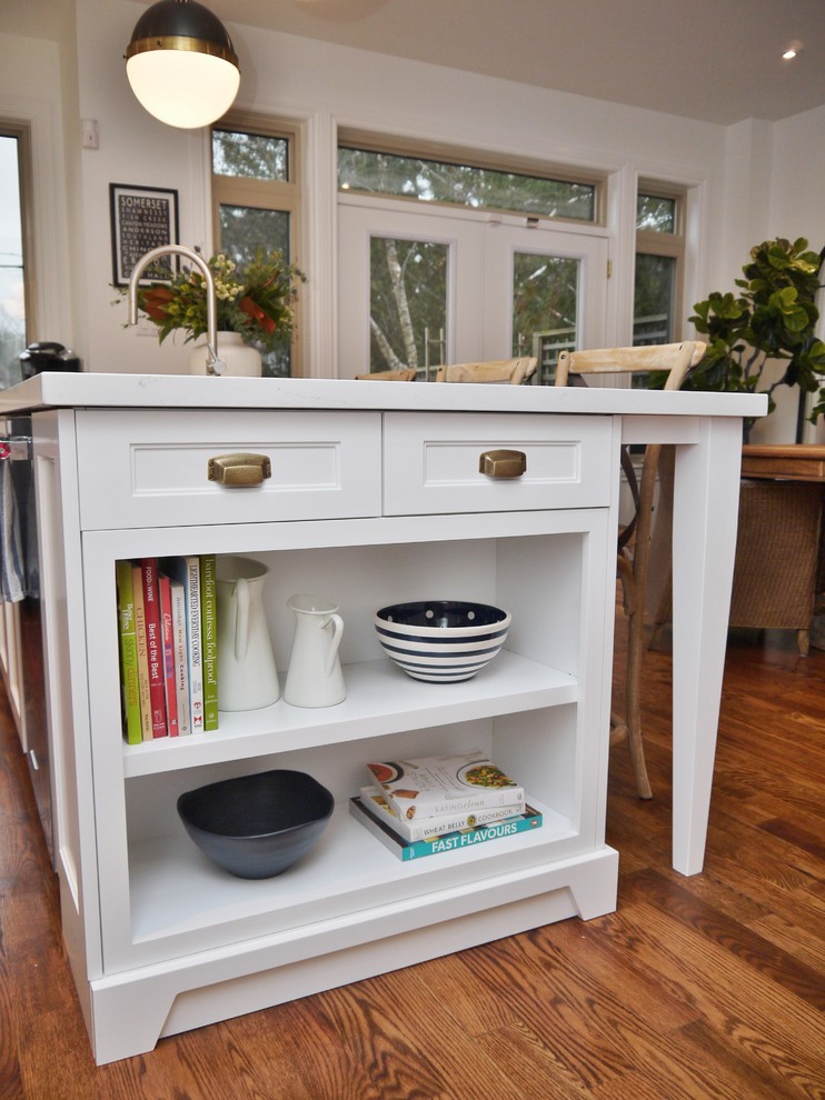 Example of a mid-sized transitional l-shaped medium tone wood floor and brown floor eat-in kitchen design in Toronto with an undermount sink, shaker cabinets, blue cabinets, quartz countertops, white backsplash, subway tile backsplash, stainless steel appliances, an island and white countertops