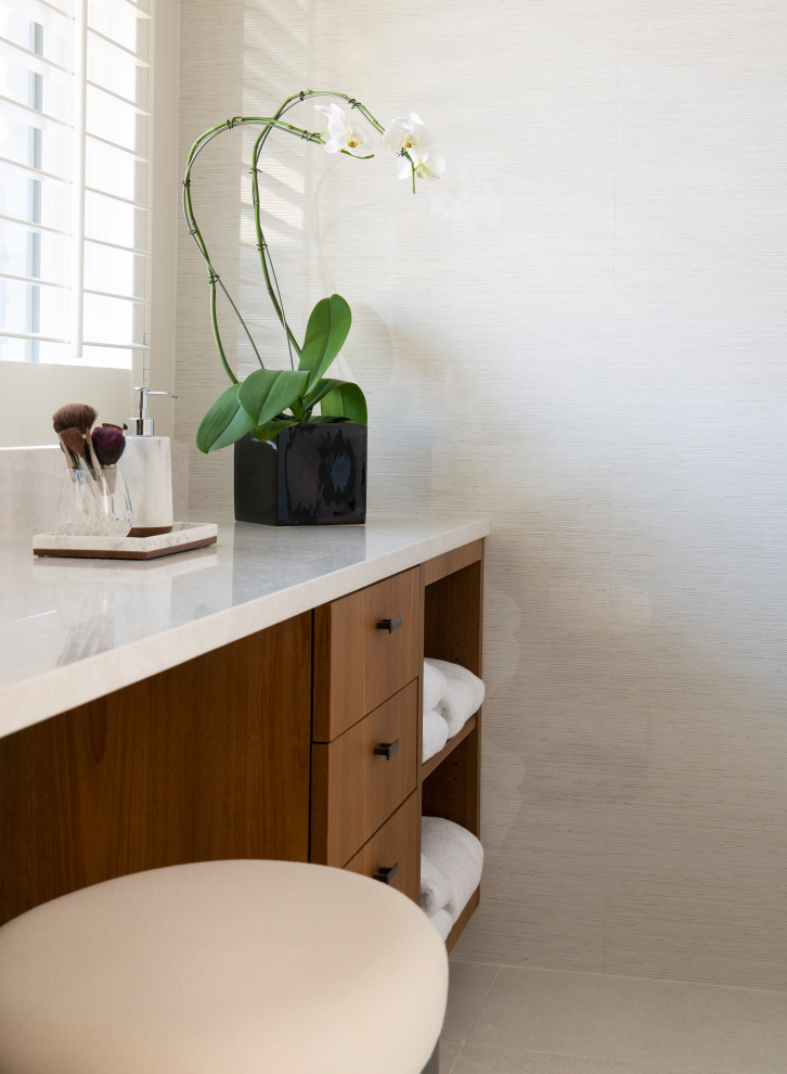 Пример оригинального дизайна: главная ванная комната среднего размера в современном стиле с плоскими фасадами, фасадами цвета дерева среднего тона, душем без бортиков, унитазом-моноблоком, белой плиткой, керамогранитной плиткой, серыми стенами, полом из керамогранита, врезной раковиной, столешницей из искусственного кварца, белым полом, душем с распашными дверями, белой столешницей, сиденьем для душа, тумбой под две раковины, подвесной тумбой и деревянными стенами